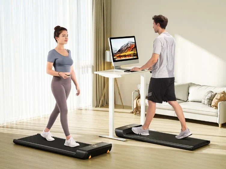 Two people using WalkingPad A1 Pro Foldable Treadmill with a standing desk.