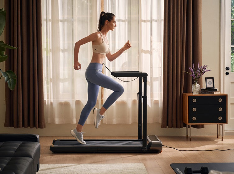 Woman running on a foldable walking pad treadmill at home in a bright living room