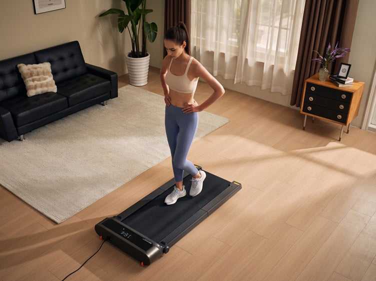 Woman walking on a compact walking pad in a small apartment living room