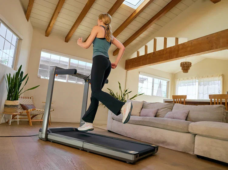 Woman running on a WalkingPad foldable treadmill in a bright modern living room